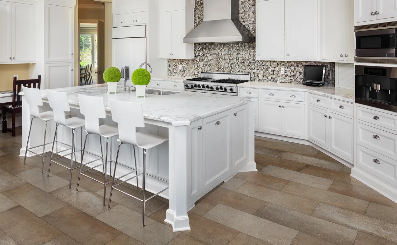 White kitchen with large center island and loads of crown molding